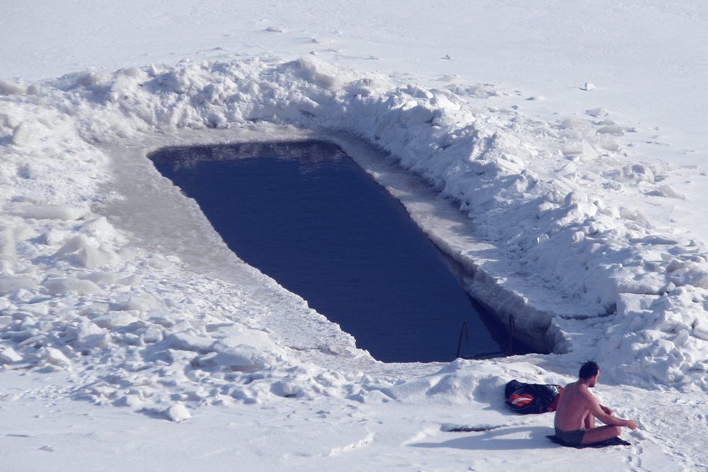 Man getting ready to jump into frozen lake.