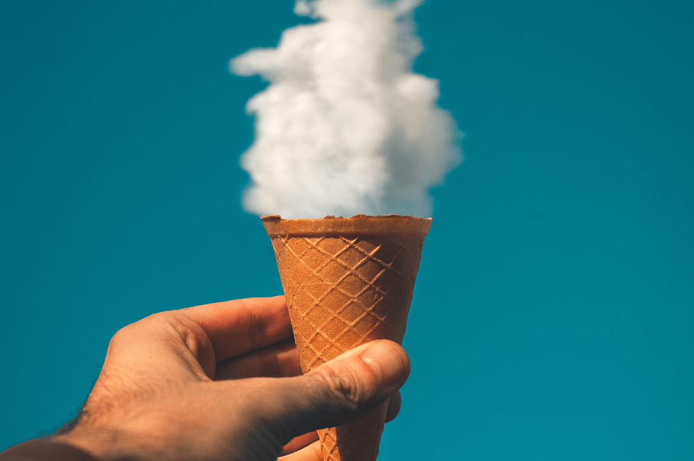 A man holding an ice cream cone to the sky.